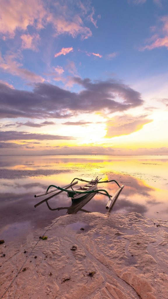 Vertical shot of a fishing boat on the sea during a beautiful sunrise in Sanur, Bali